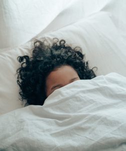 Women sleeping in bed under the covers