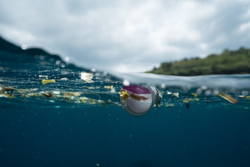 Plastic waste floating in the ocean with invisible microbeads and microplastics