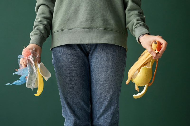 Woman holding pieces of rubbish and plastic