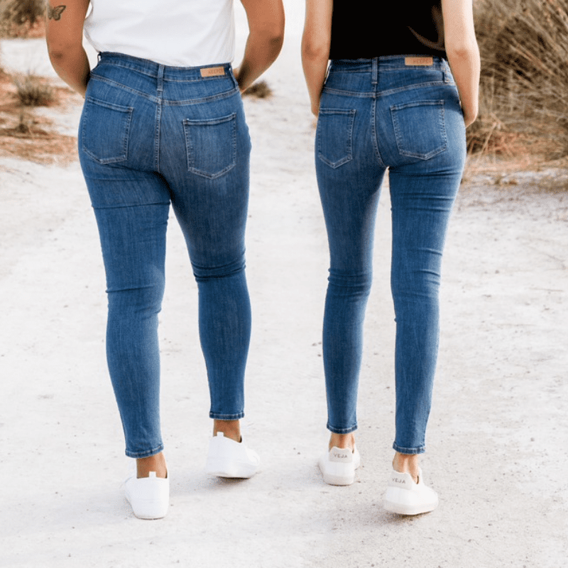 Two women wearing keeper denim jeans walking away from the camera